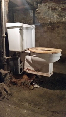 Older plumbing fixture in a basement