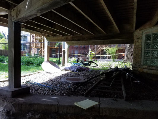 Plumbing access area beneath a raised structure